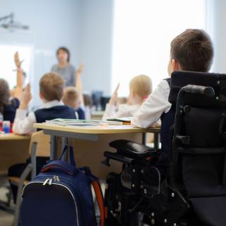 boy in wheelchair sitting in a classroom